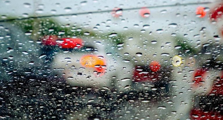 Gouttes de pluie sur vitre de voiture avec trafic flou en arrière-plan