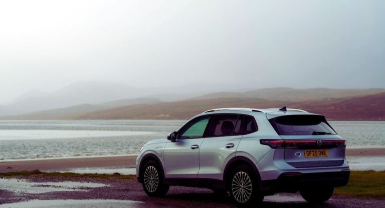 SUV garé au bord d'un lac dans un paysage brumeux