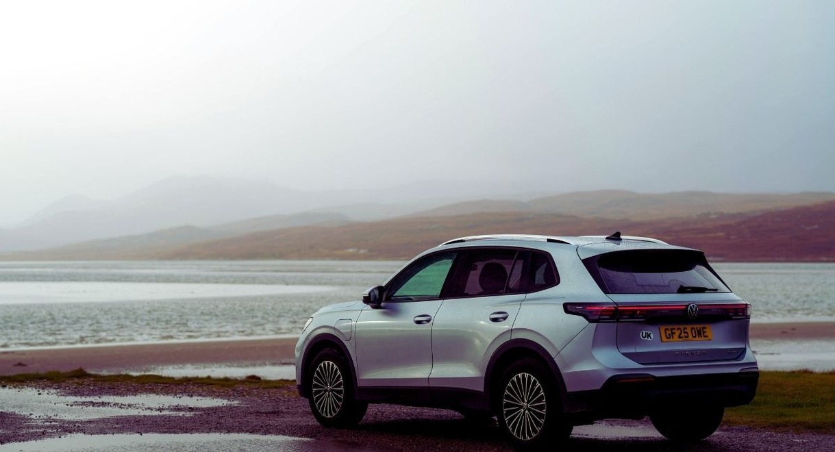 SUV garé au bord d'un lac dans un paysage brumeux