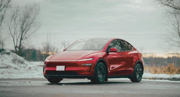Voiture électrique compacte rouge stationnée dans un paysage hivernal enneigé