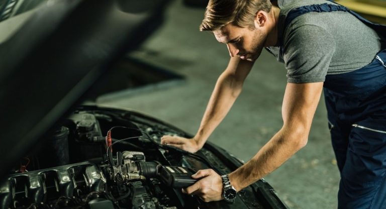 Mécanicien automobile utilisant un outil de diagnostic électronique en atelier