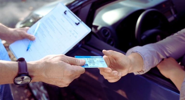 Moniteur remettant le permis de conduire à un examinateur en extérieur