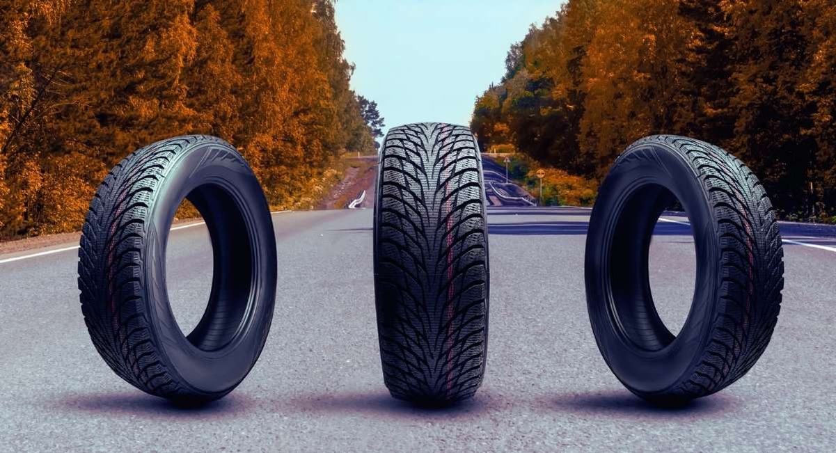 Trois pneus hiver posés sur une route en automne en attente de remplacement saisonnier