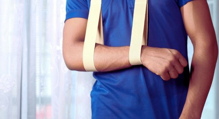 Homme portant une attelle en echarpe pour immobiliser le bras