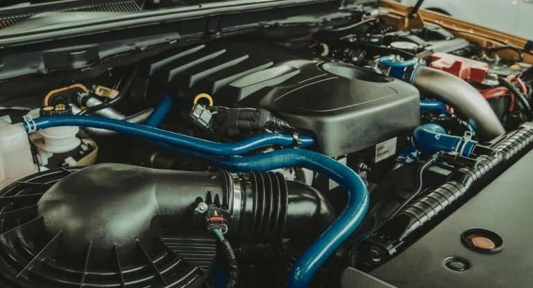 Compartiment moteur d'une voiture avec durites et cache-moteur apparents