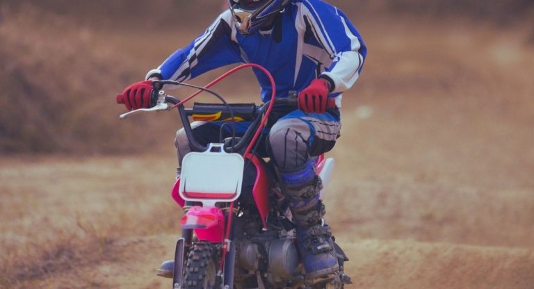 Jeune pilote equipe conduisant une mini moto sur un chemin de terre