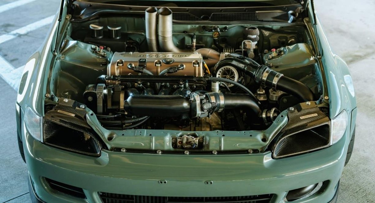 Vue rapprochee d'un moteur de voiture capot ouvert dans un garage