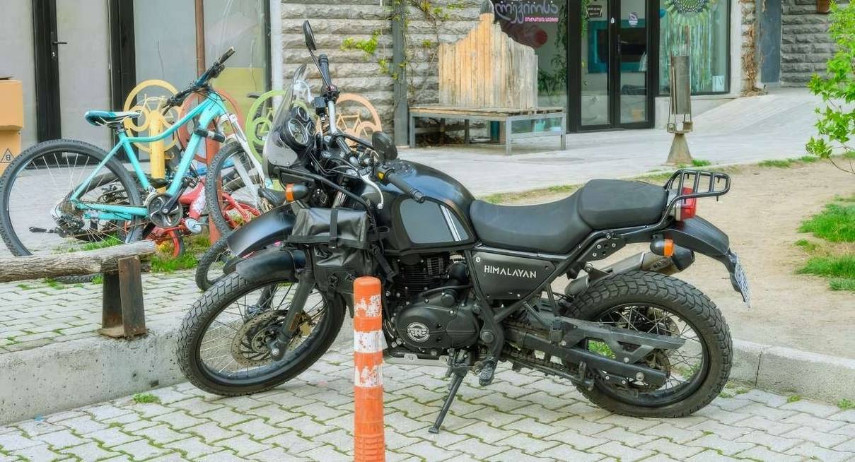 Moto noire de type roadster garee sur un trottoir en ville