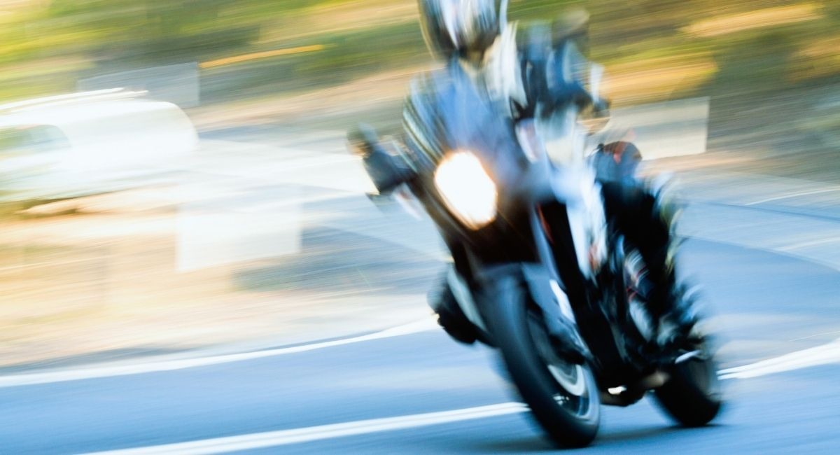 Motard en pleine vitesse sur une route avec flou de mouvement