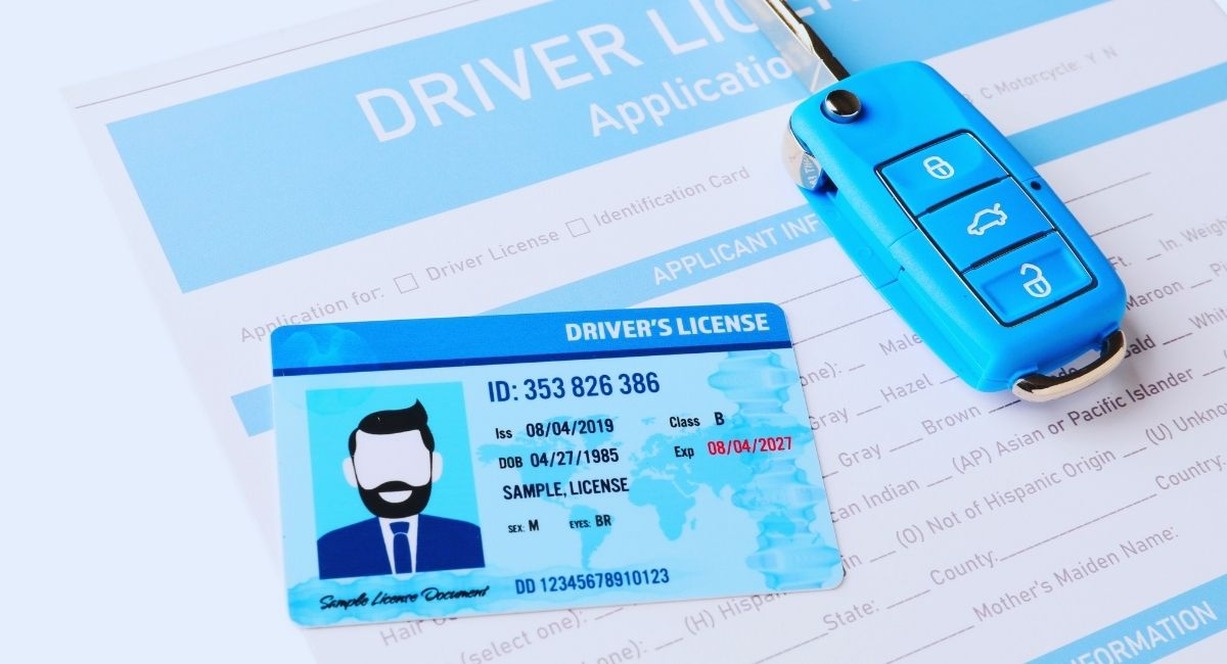 Permis de conduire pose sur un formulaire de demande a cote d'une cle de voiture