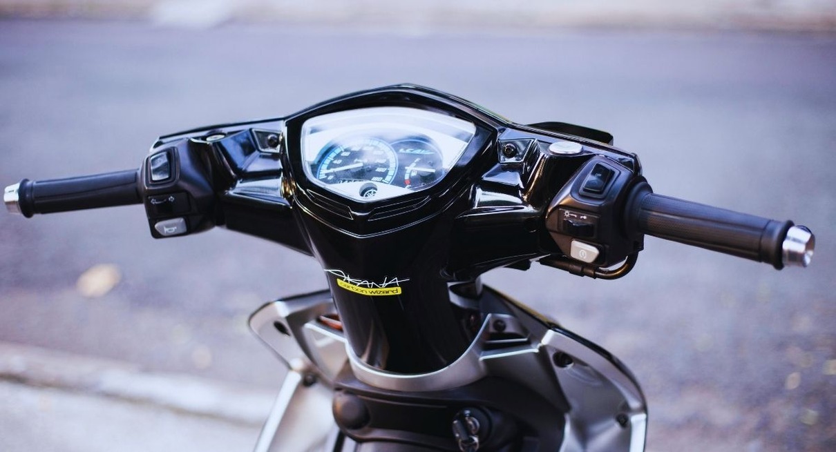 Gros plan sur le compteur de vitesse et le guidon d'un scooter
